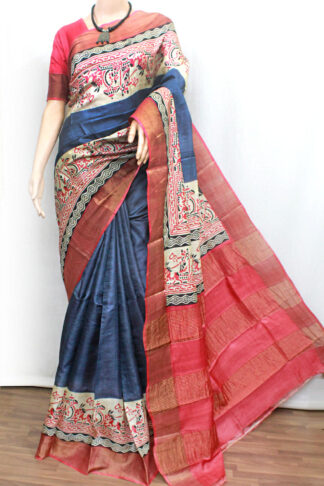 Slate grey body paired with intricately handcrafted ethnic block prints in vibrant red and black. The rich coral-red zari woven border and pallu add a luxurious touch, creating a striking contrast that enhances its timeless appeal.
